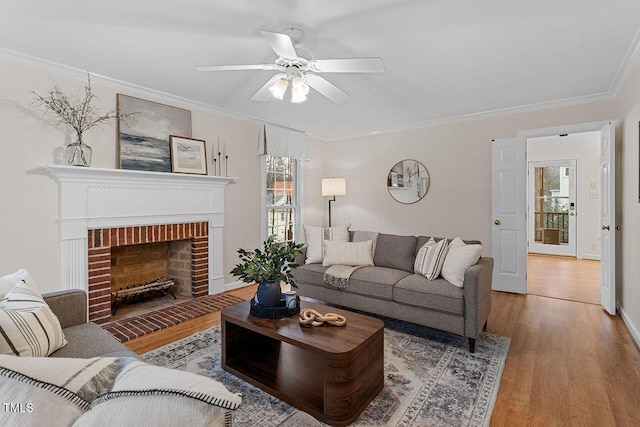 living room with a brick fireplace, ceiling fan, ornamental molding, and wood-type flooring