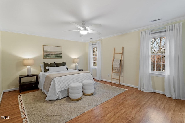 bedroom with hardwood / wood-style flooring, ceiling fan, and crown molding