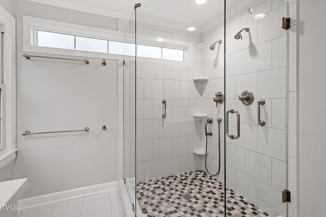 bathroom with tile patterned flooring, ornamental molding, walk in shower, and a wealth of natural light