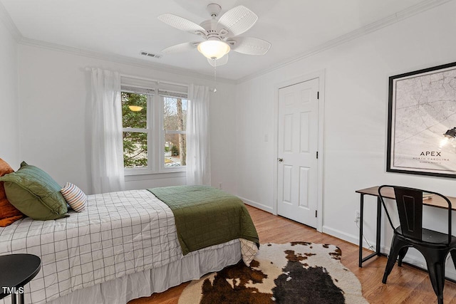 bedroom featuring ceiling fan, light wood-type flooring, and crown molding