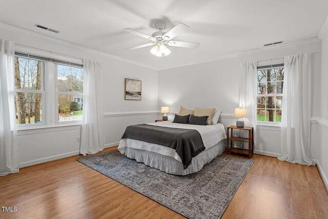 bedroom with ceiling fan, crown molding, and wood-type flooring