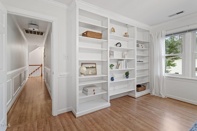 interior space featuring ornamental molding, a wealth of natural light, and light hardwood / wood-style flooring