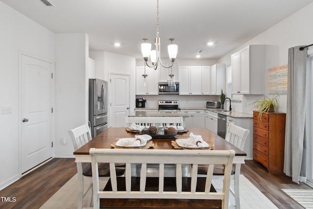 kitchen featuring white cabinetry, hanging light fixtures, a kitchen island, and stainless steel appliances