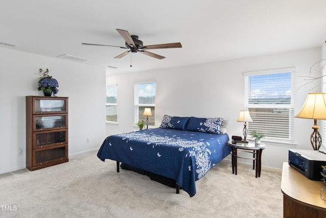 bedroom with light carpet, multiple windows, and ceiling fan