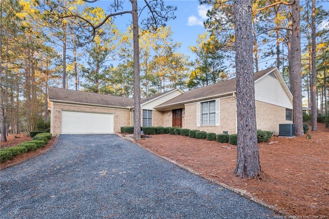 single story home with a garage and central air condition unit