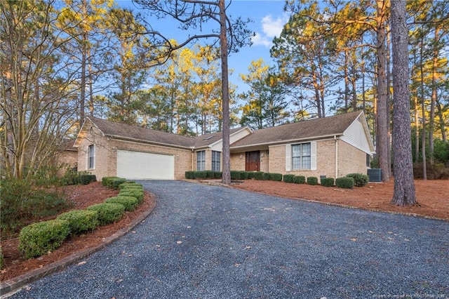 single story home with a garage and central AC unit