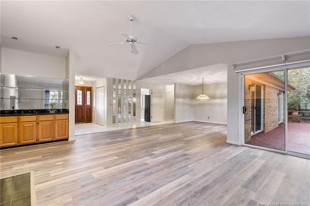 unfurnished living room featuring ceiling fan, light hardwood / wood-style flooring, and lofted ceiling