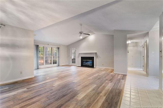 unfurnished living room featuring ceiling fan, light hardwood / wood-style flooring, and vaulted ceiling