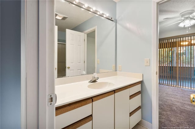 bathroom with ceiling fan, a textured ceiling, and vanity