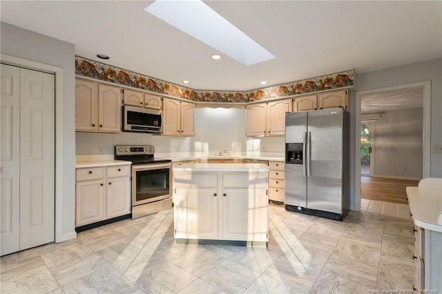 kitchen featuring a skylight, sink, a kitchen island, and stainless steel appliances