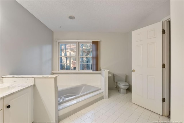 bathroom with vanity, tile patterned floors, toilet, a textured ceiling, and tiled tub