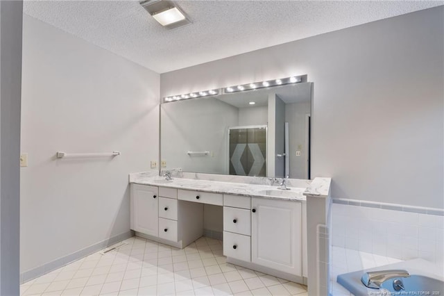 bathroom with vanity, shower with separate bathtub, a textured ceiling, and tile patterned flooring