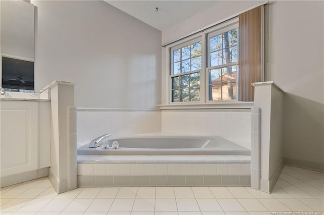 bathroom with a textured ceiling, tiled tub, tile patterned flooring, and vaulted ceiling