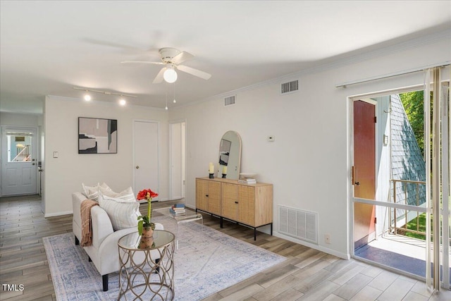 living room with ceiling fan, crown molding, and light hardwood / wood-style floors