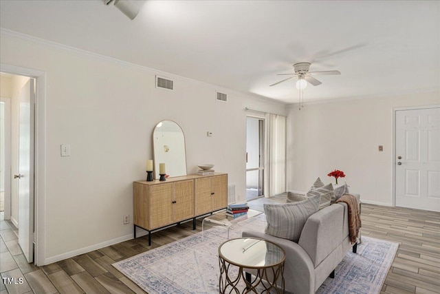 living room featuring ceiling fan, ornamental molding, and light hardwood / wood-style flooring