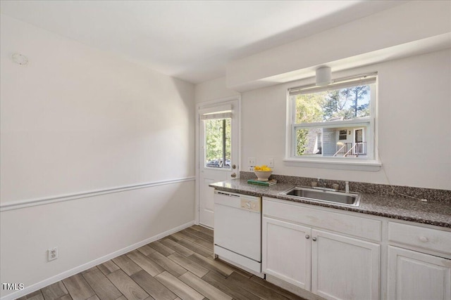 kitchen featuring white cabinets, white dishwasher, light hardwood / wood-style flooring, and sink