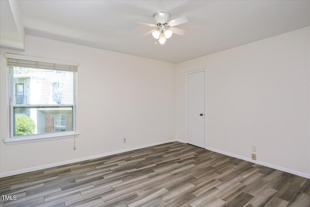 spare room with ceiling fan and dark wood-type flooring