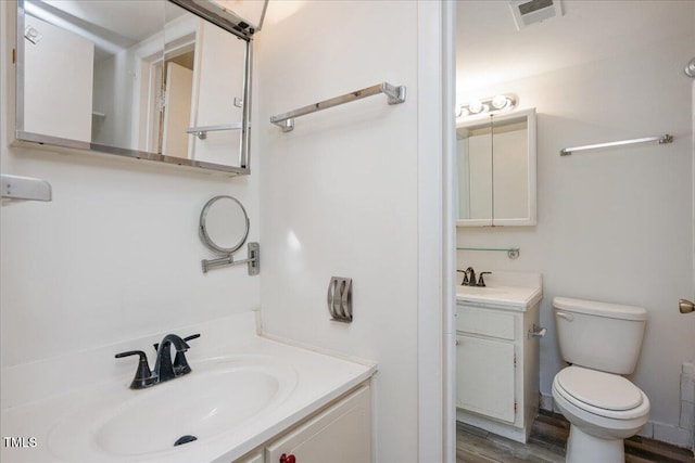 bathroom featuring vanity, wood-type flooring, and toilet