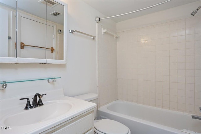 full bathroom featuring tiled shower / bath, vanity, and toilet