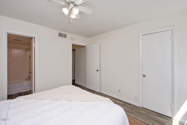 bedroom featuring hardwood / wood-style flooring, ceiling fan, and connected bathroom