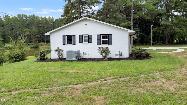 view of side of property with a yard and cooling unit