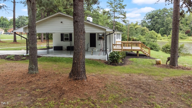 rear view of property with a wooden deck and a yard