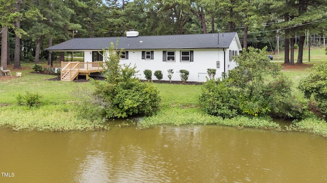 back of house featuring a deck with water view and a yard