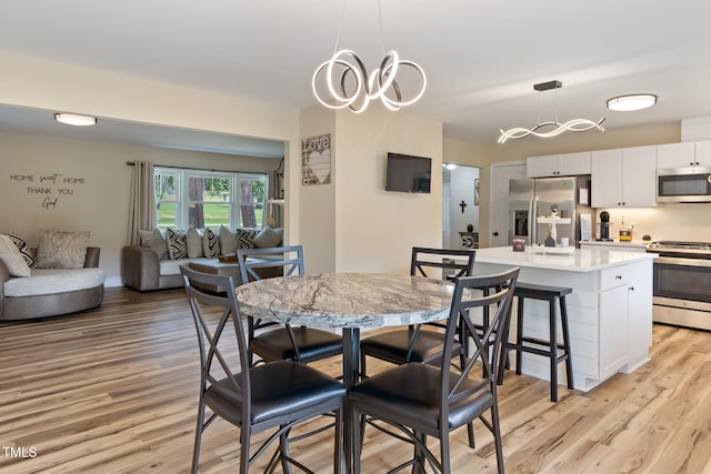 dining area with a chandelier and light wood-type flooring