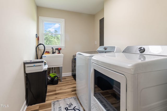 laundry area with light wood-type flooring and washer and clothes dryer