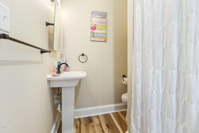 bathroom featuring hardwood / wood-style floors and toilet