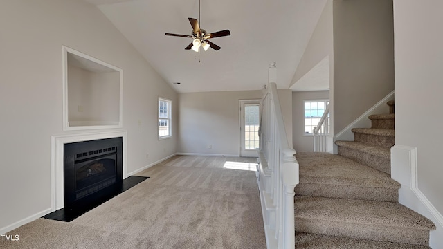 unfurnished living room featuring ceiling fan, high vaulted ceiling, and light colored carpet