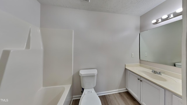 full bathroom featuring shower / bath combination, vanity, a textured ceiling, wood-type flooring, and toilet