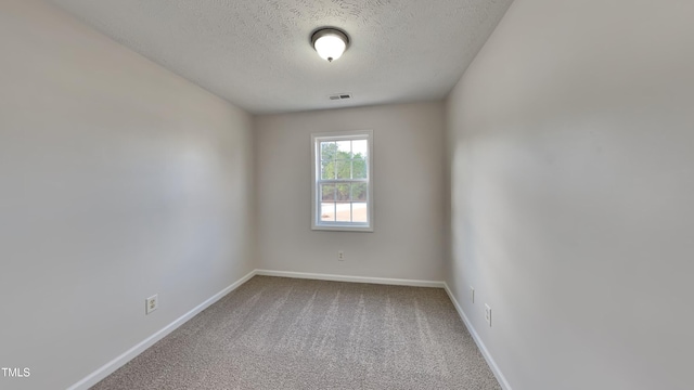 unfurnished room featuring carpet flooring and a textured ceiling