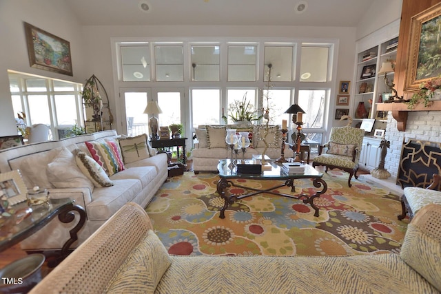 living room with built in shelves, a wealth of natural light, and lofted ceiling