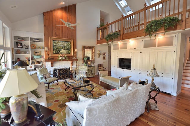 living room featuring ceiling fan, high vaulted ceiling, and a brick fireplace