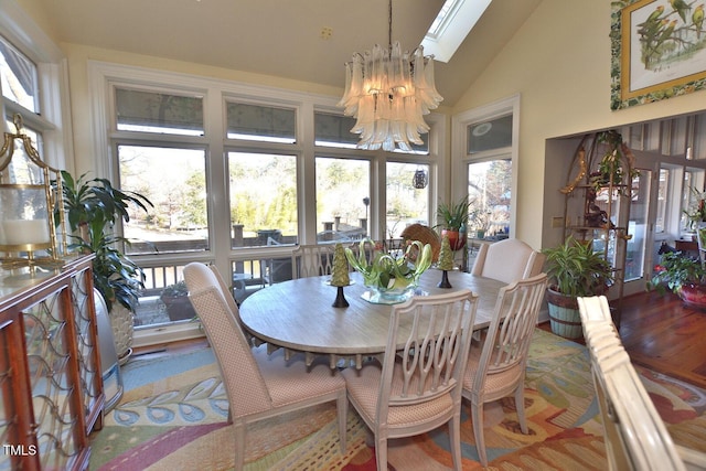 dining area with light hardwood / wood-style flooring, lofted ceiling, and an inviting chandelier