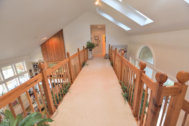 hall featuring light carpet and lofted ceiling with skylight