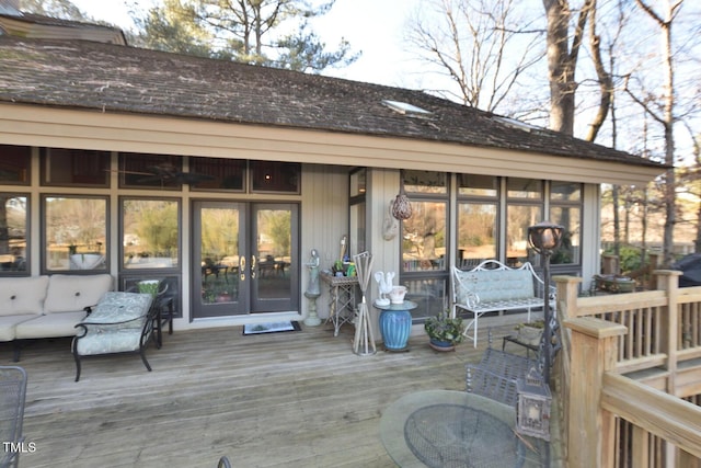 deck featuring an outdoor living space and a sunroom