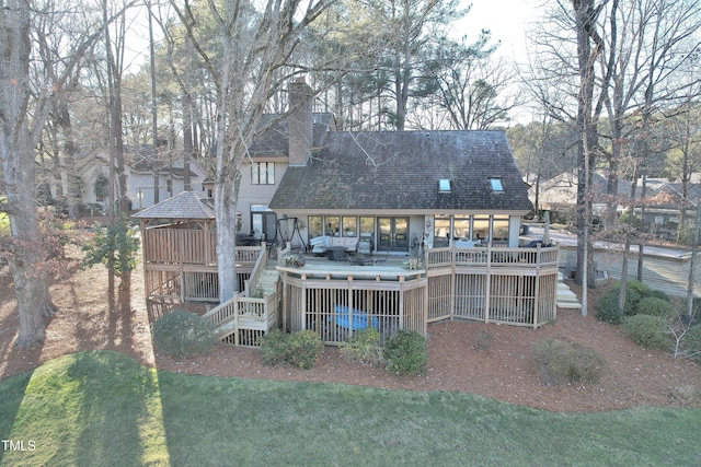 back of house featuring a deck and a lawn