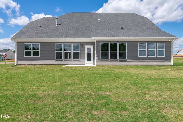 rear view of house with a yard and a shingled roof