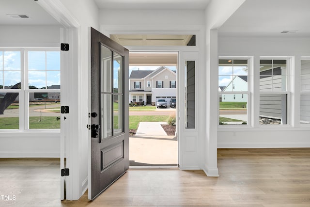 entrance foyer featuring healthy amount of natural light, light wood-type flooring, and baseboards