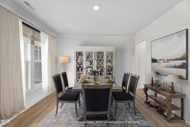 dining room featuring wood finished floors, crown molding, and recessed lighting