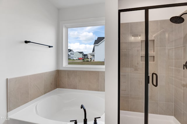 bathroom featuring a stall shower and a bath