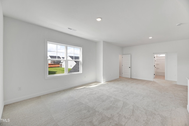 empty room with light carpet, recessed lighting, and baseboards
