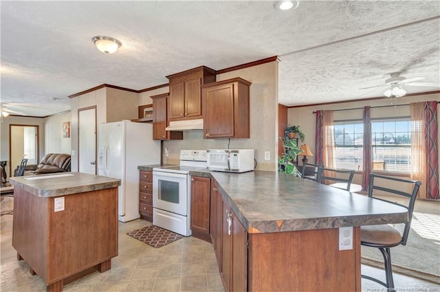 kitchen with white appliances, dark countertops, ceiling fan, open floor plan, and under cabinet range hood