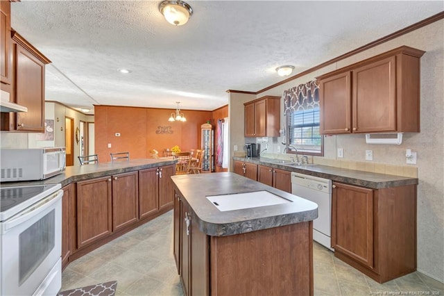 kitchen featuring pendant lighting, dark countertops, white appliances, and a peninsula