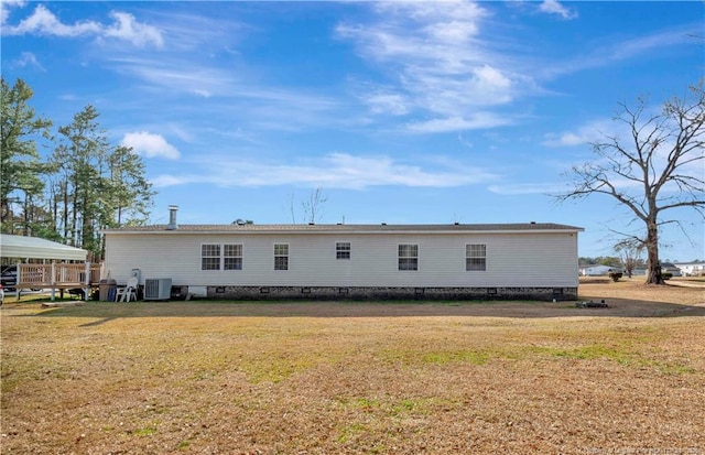 rear view of property with crawl space, a lawn, and central air condition unit