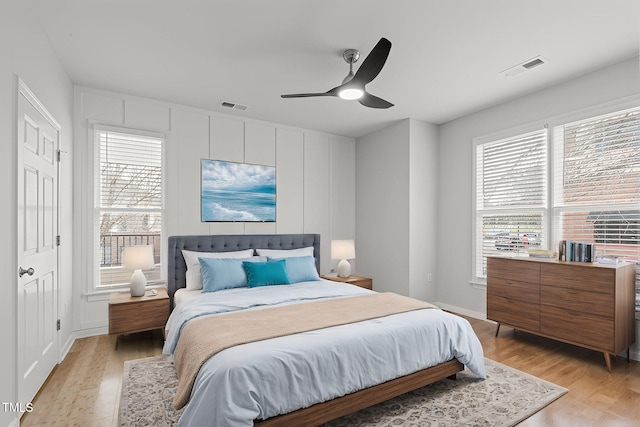 bedroom featuring light wood-style flooring, multiple windows, and visible vents