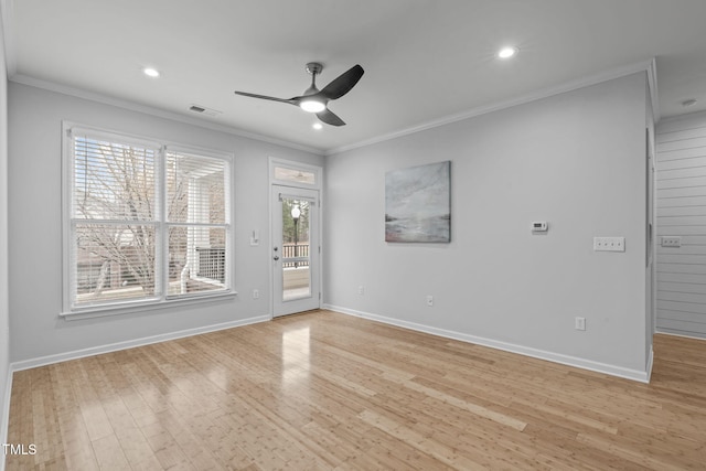 spare room with light wood-style flooring, ornamental molding, and baseboards