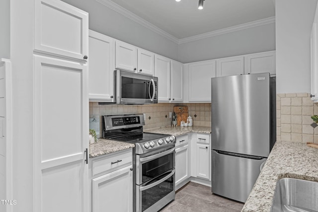 kitchen featuring ornamental molding, appliances with stainless steel finishes, white cabinetry, and light stone countertops